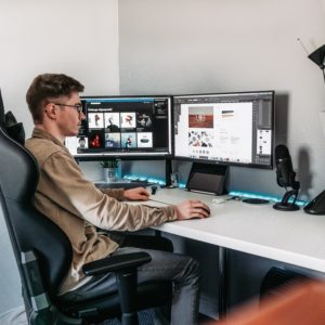 Man sitting at desk with two monitors