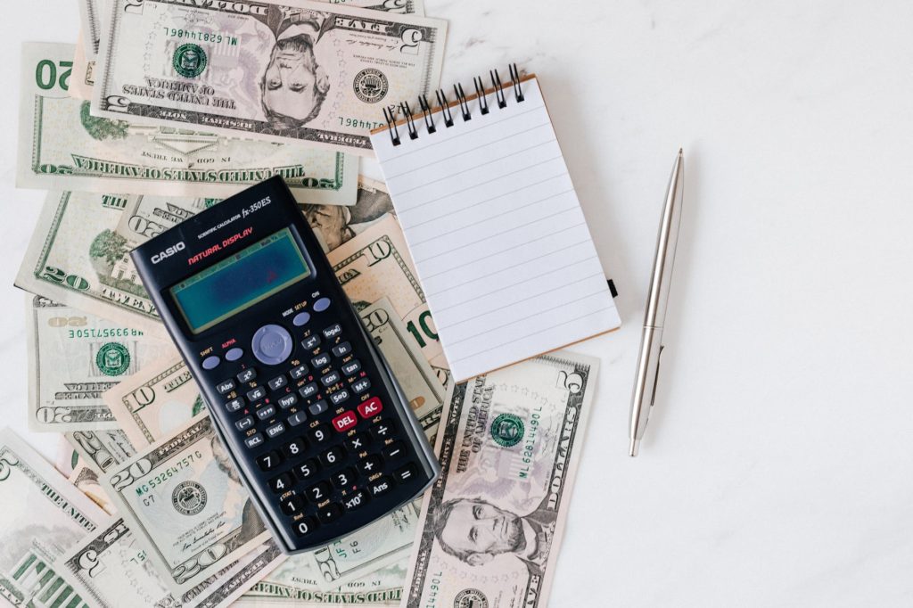 Calculator and notepad sitting on money