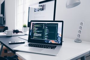 Laptop on desk with code